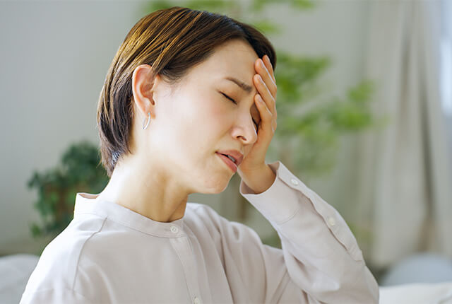 額に手を当てている女性