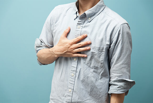 胸に手を当てている男性